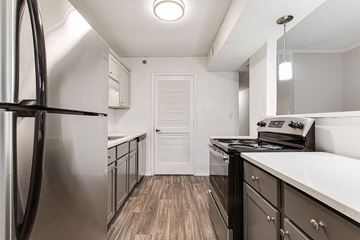 Smyrna apartment for rent - A kitchen with a stainless steel refrigerator and a stove top oven.