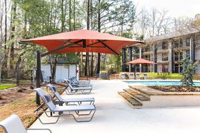 Smyrna apartment for rent - A pool area with sun loungers and a red umbrella.