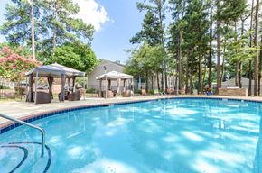 Marietta apartment for rent - A large swimming pool surrounded by trees and pavilions.
