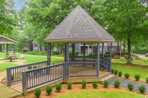 Stockbridge apartment for rent - A gazebo with a grey roof is surrounded by a metal fence and small bushes.