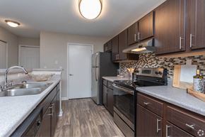 Stockbridge apartment for rent - A kitchen with dark wood cabinets and a black stove top oven.