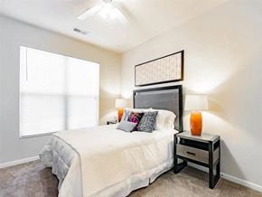 Granger apartment for rent - A bedroom with a bed, nightstand, and a ceiling fan.