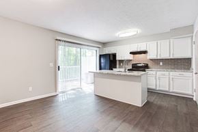 Marietta apartment for rent - A kitchen with white cabinets and a black fridge.