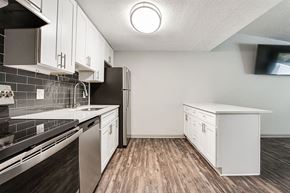 Woodstock apartment for rent - A kitchen with white cabinets and a black refrigerator.