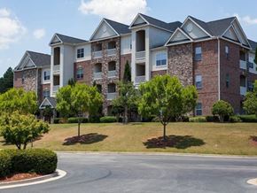 Stockbridge apartment for rent - A large brick apartment building with a green lawn in front.