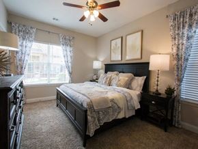 Mcdonough apartment for rent - A bedroom with a bed, nightstand, and a ceiling fan.