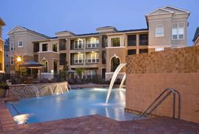 Kingwood apartment for rent - A swimming pool in front of a building with a fountain.