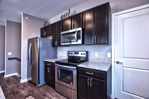 Goshen apartment for rent - A kitchen with dark brown cabinets and stainless steel appliances.