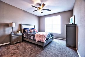 Goshen apartment for rent - A bedroom with a bed, dresser, and ceiling fan.
