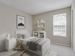 Douglasville apartment for rent - A bedroom with a poster on the wall that says "Adventure is out there" and a bed with a grey blanket.