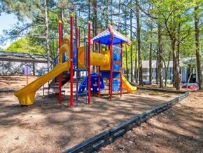 Douglasville apartment for rent - A playground with a yellow slide and a blue and yellow play structure.