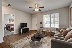 Waxahachie apartment for rent - A living room with a grey couch, a coffee table, and a ceiling fan.