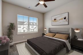 Waxahachie apartment for rent - A bedroom with a large bed and a ceiling fan.
