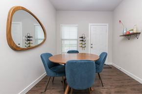 Waxahachie apartment for rent - A dining room with a round table and blue chairs.