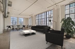 Los Angeles apartment for rent - A black sofa sits in a spacious room with a white coffee table in front of it.