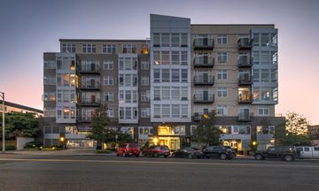 Everett apartment for rent - A large apartment building with cars parked in front.
