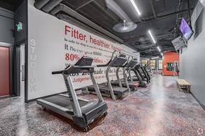 Calgary apartment for rent - A gym with treadmills and a sign that says "Fitter, healthier, happier".