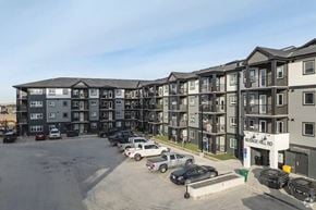 Calgary apartment for rent - A parking lot in front of a building with the sign 60 Sage Hill Rd.
