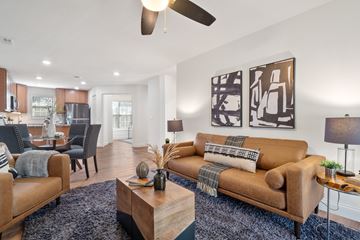 Chesterfield apartment for rent - A living room with a brown couch and a ceiling fan.
