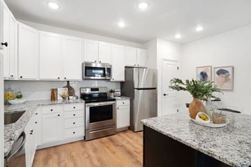 St. Peters apartment for rent - A kitchen with white cabinets and a granite countertop.