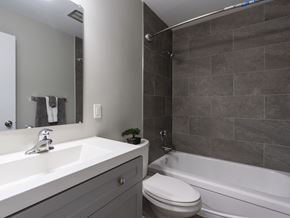 Kitchener apartment for rent - A bathroom with a white sink, toilet, and bathtub.