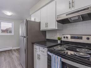 Kitchener apartment for rent - A kitchen with a black stove top oven and a black counter top.
