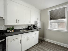 Hamilton apartment for rent - A kitchen with white cabinets and a black stove top.