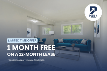 Hamilton apartment for rent - A living room with a blue couch and a 1 month free offer on a 12-month lease.