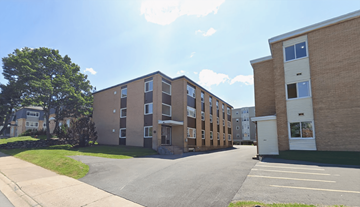 Halifax apartment for rent - A sunny day at a residential area with apartment buildings and a parking lot.
