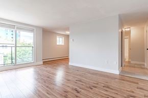 London apartment for rent - A spacious room with wooden flooring and white walls.