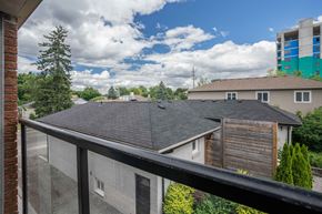 London apartment for rent - A view from a balcony overlooking a residential area with houses and trees.