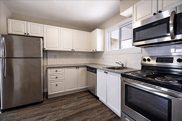 Kitchener townhouse for rent - A kitchen with white cabinets and stainless steel appliances.