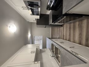 London apartment for rent - A modern kitchen with stainless steel appliances and white countertops.