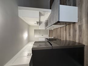 London apartment for rent - A modern kitchen with a dark countertop and white cabinetry.