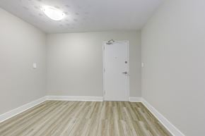Cambridge apartment for rent - A room with a white door and wooden flooring.