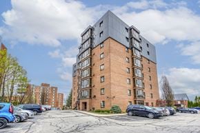 Waterloo apartment for rent - A large brick building with a parking lot in front of it.