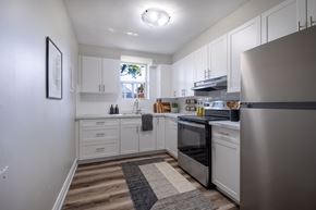 Hamilton apartment for rent - A modern kitchen with white cabinets and stainless steel appliances.