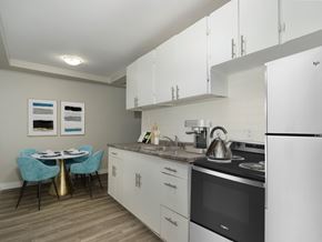London apartment for rent - A kitchen with a table and chairs and a fridge.