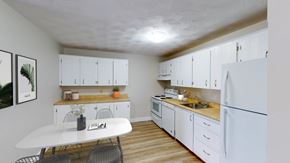 Moncton apartment for rent - A kitchen with white cabinets and a white fridge.