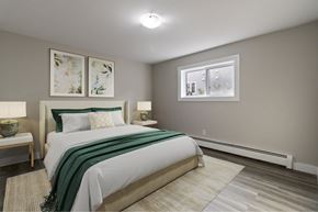Moncton apartment for rent - A bedroom with a large bed and two lamps.