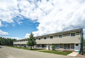 Riverview apartment for rent - A long building with a parking lot in front.