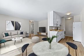 London apartment for rent - A modern living room with a grey marble table and black chairs.