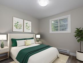 Kitchener apartment for rent - A bedroom with a large bed and a window showing trees outside.