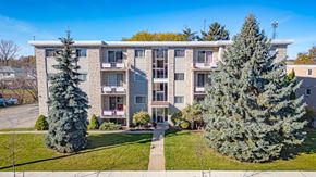 Kitchener apartment for rent - A large apartment building with a green lawn in front.