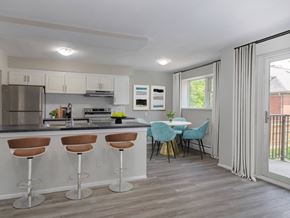 London apartment for rent - A kitchen with a bar area and a dining table with chairs.