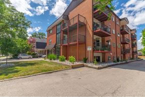 London apartment for rent - A large red brick apartment building with a parking lot in front.