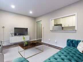 London apartment for rent - A living room with a white cabinet, a blue couch, and a mirror on the wall.