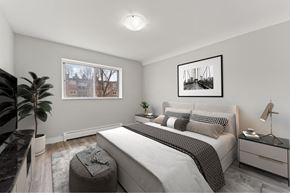 Kitchener apartment for rent - A bedroom with a large bed, a window, and a painting on the wall.
