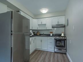 Kitchener apartment for rent - A kitchen with a stainless steel refrigerator and a stove with a pot on it.