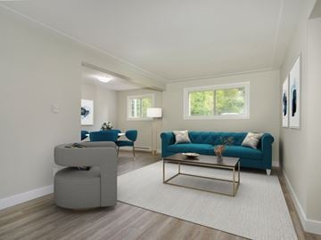 Kitchener apartment for rent - A living room with a blue couch and a grey ottoman.